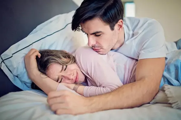 A couple snuggles together in bed and Girl crying